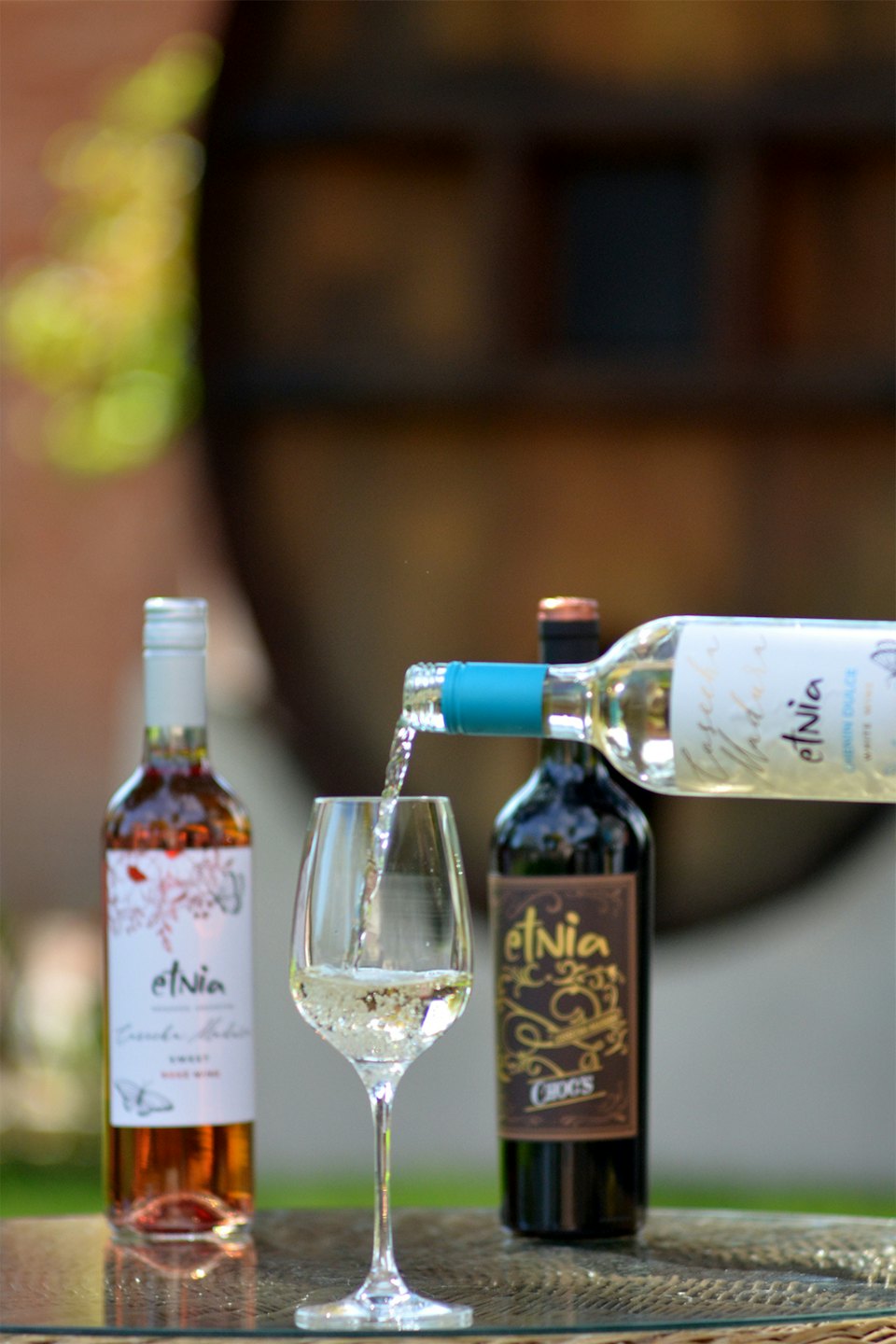 White wine poured into a glass on a glass-topped table.