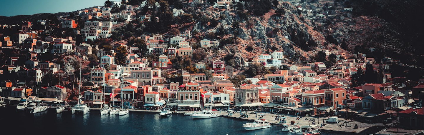 Colorful houses and boats at a hillside coastal harbor.